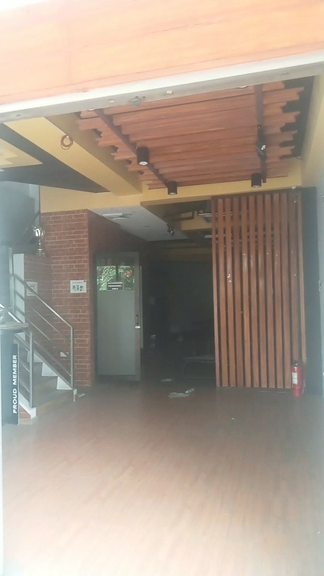 A commercial unit in the same row fitted out as a gym, timber slat screen and brick to the frontage