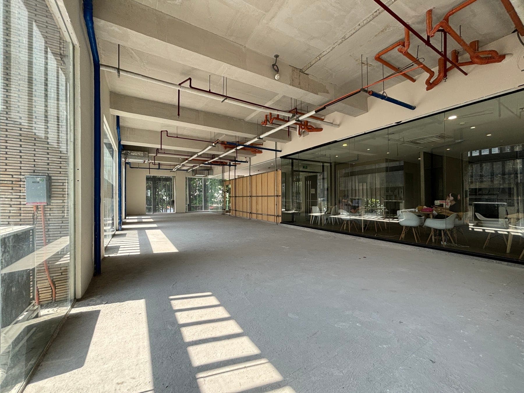 The same floor plate with the glazed co-working area visible through the partition to the right