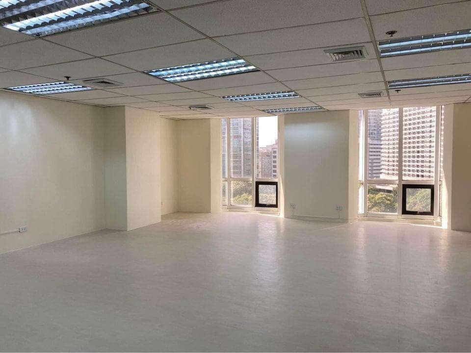 Fitted office with a suspended ceiling and recessed lighting, glazing on two sides looking out to neighbouring towers
