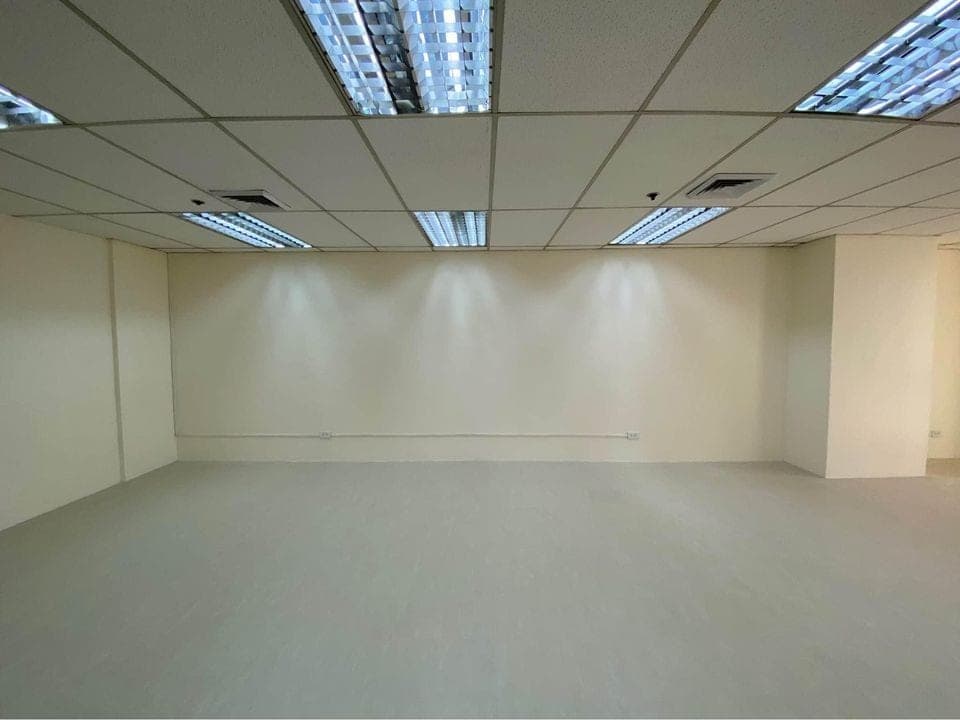 Blank internal wall of the fitted unit under a suspended ceiling, with power outlets at skirting level